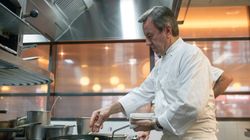 Catering chef in white uniform preparing food in a professional kitchen at Cuisine Boulud New York
