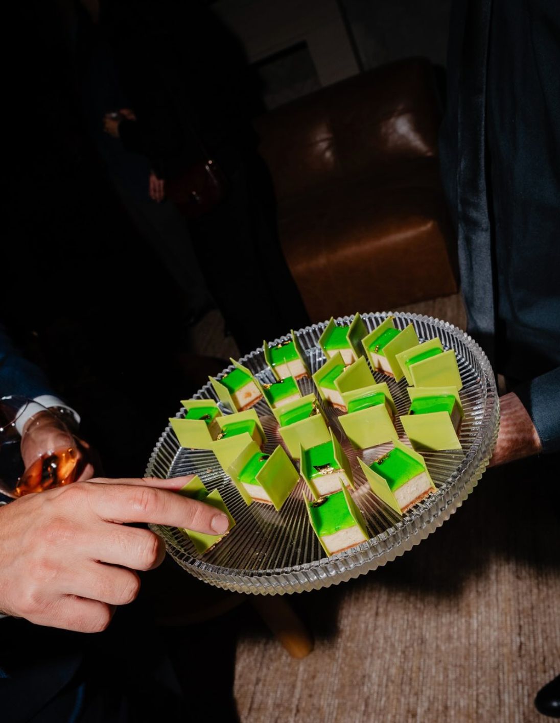 Stylish dessert served on a clear platter, featuring vibrant green and yellow rectangular treats at Cuisine Boulud.