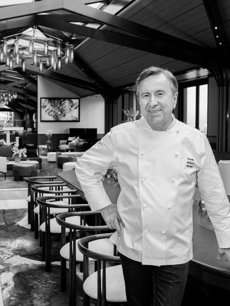 Featuring Chef Daniel Boulud in a stylish restaurant setting, emphasizing luxury and elegance in catering services.